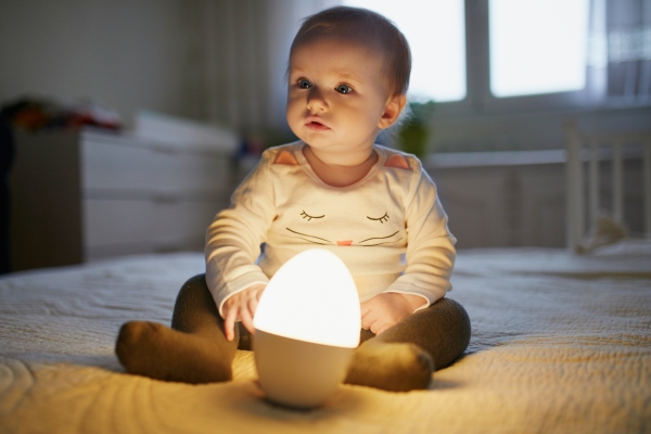 Baby spielt mit Nachttischlampe