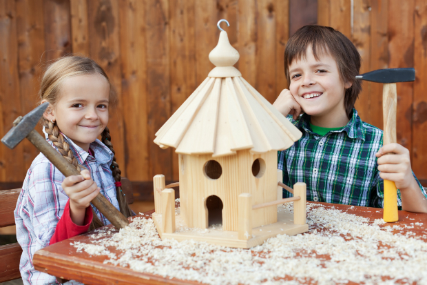 Zwei Kinder bauen ein Vogelhaus