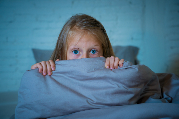 Schlafloses Maedchen versteckt sich hinter der Decke